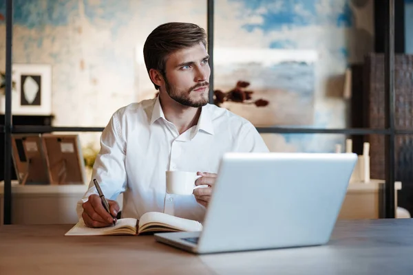 Happy man working at office, doing notes, sitting at desk. — Stock Photo, Image