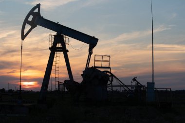 Turuncu gün batımında yağ pompası.