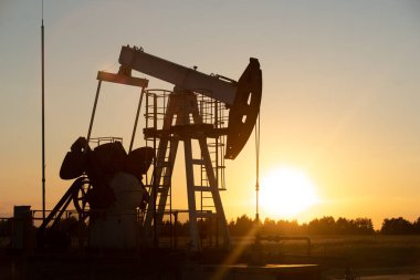 Turuncu gün batımında yağ pompası.