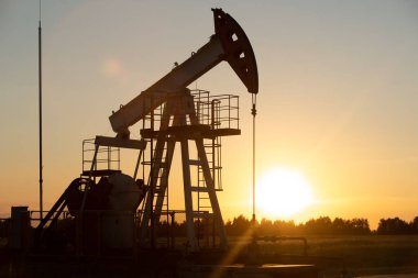 Turuncu gün batımında yağ pompası.