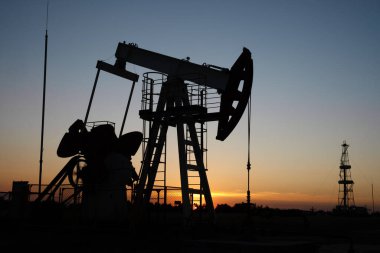 Turuncu gün batımında yağ pompası.