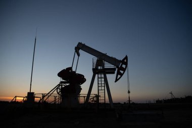 Turuncu gün batımında yağ pompası.