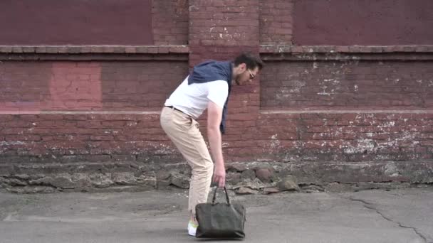 Веселый и счастливый бизнесмен активно танцует на улице рядом с городской стеной — стоковое видео