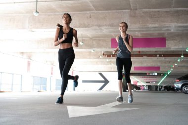 Spor kıyafetleri içinde sağlıklı kadınlar dışarıda koşar ve sağlıklı bir yaşam sürerler.