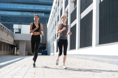 Spor kıyafetleri içinde sağlıklı kadınlar dışarıda koşar ve sağlıklı bir yaşam sürerler.