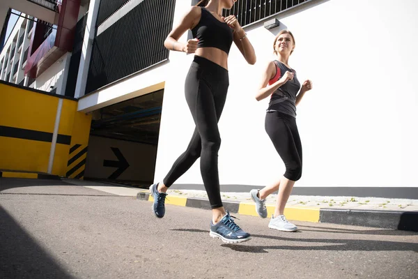 Přizpůsobit ženy ve sportovním oblečení jogging venku a žít zdravý životní styl — Stock fotografie