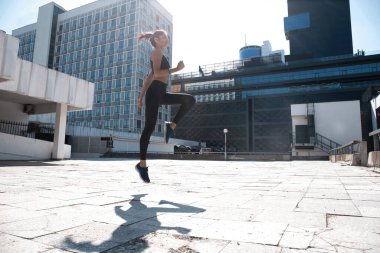 Zayıf esmer kadın spor kıyafetleri giyiyor spor yaparken atlıyor..