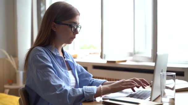 Konzentrierte junge Geschäftsfrau arbeitet zu Hause am Computer — Stockvideo