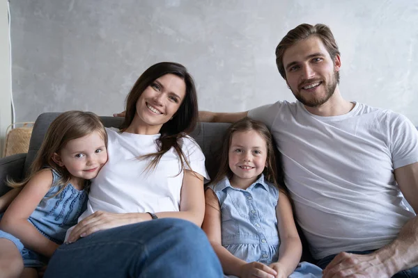 Glada familj hemma sitter i soffan. — Stockfoto