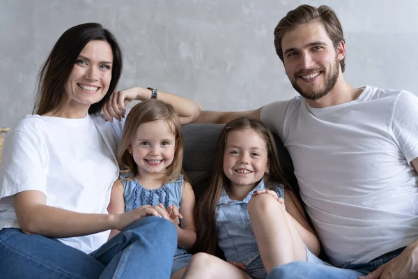 Vrolijke familie thuis zittend op de bank. — Stockfoto