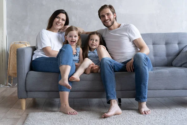 Famiglia allegra a casa seduta sul divano. — Foto Stock