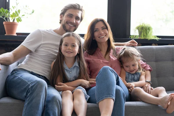 Famille joyeuse à la maison assis dans le canapé. — Photo