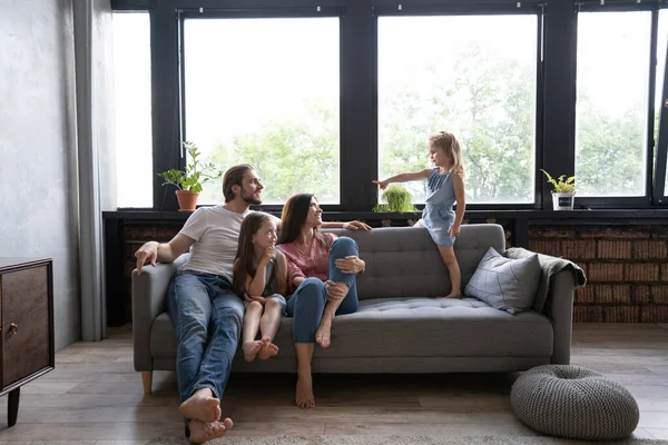 Famille joyeuse à la maison assis dans le canapé. — Photo