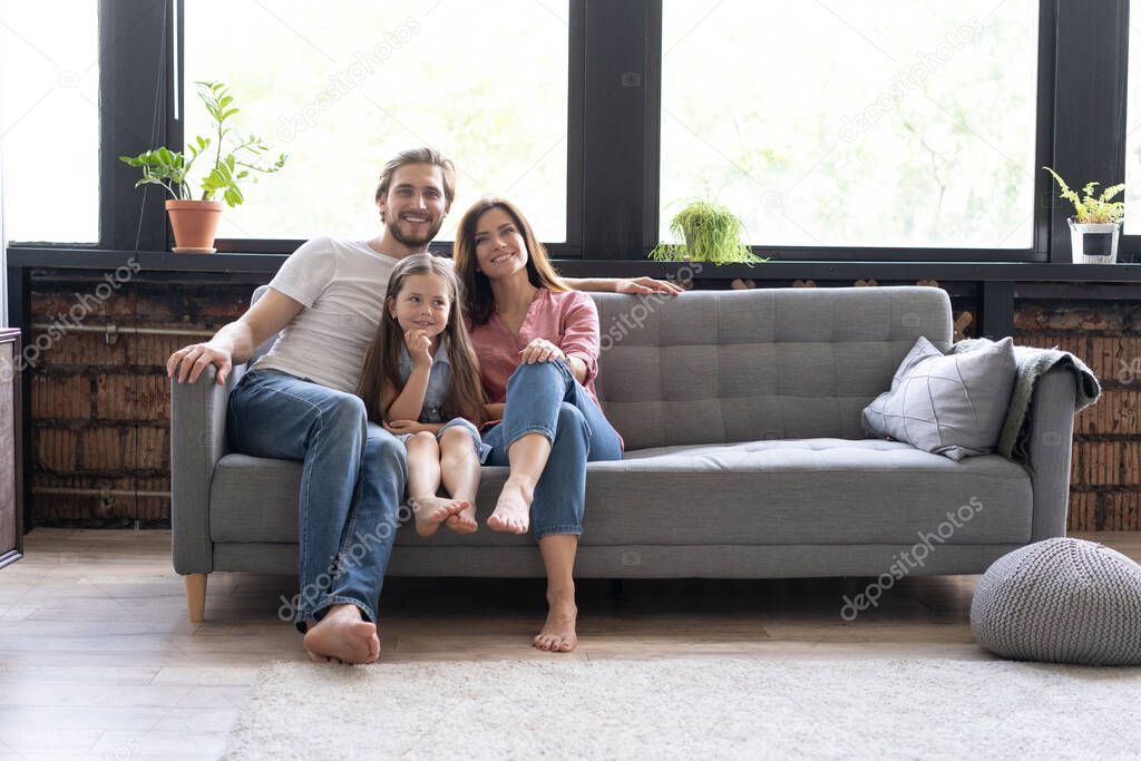 Cheerful family at home sitting in sofa.