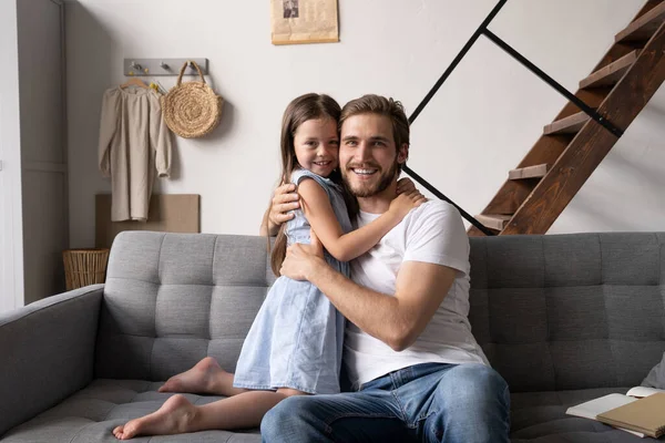 Felice padre e figlia che si abbracciano e si siedono sul divano. — Foto Stock