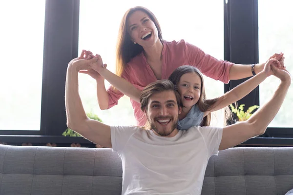 Gelukkig vrolijke ouders hebben plezier met leuke kinderen dochters spelen op de bank — Stockfoto