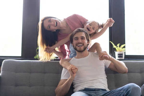 Felice genitori allegri divertirsi con bambini simpatici figlie che giocano sul divano — Foto Stock