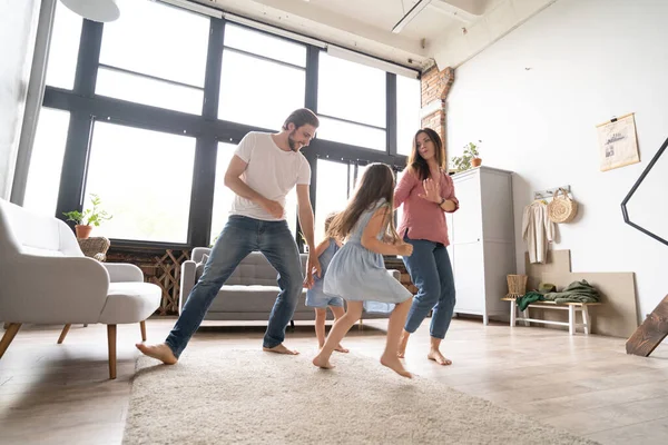 Feliz familia madre padre e hija hija bailando en casa. — Foto de Stock