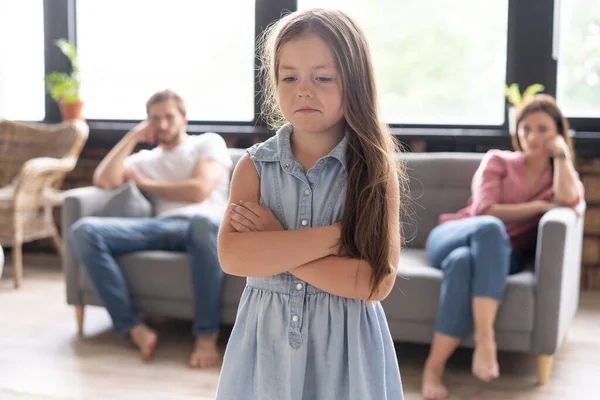 Närbild av en ledsen flicka medan föräldrar grälar i hemmet. — Stockfoto