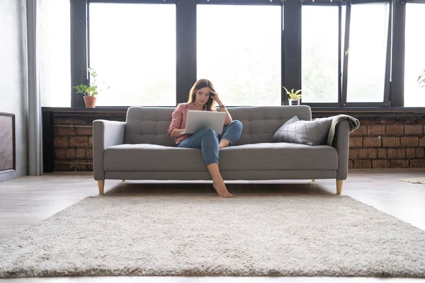 Mujer joven trabajando en el ordenador portátil en el apartamento loft. — Foto de Stock