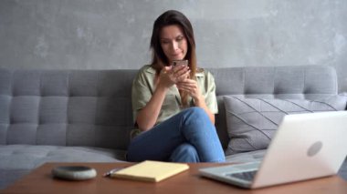 Akıllı telefonu tutan kadın, alışveriş için mobil uygulamalar kullanarak telefon ekranına bakıyor.