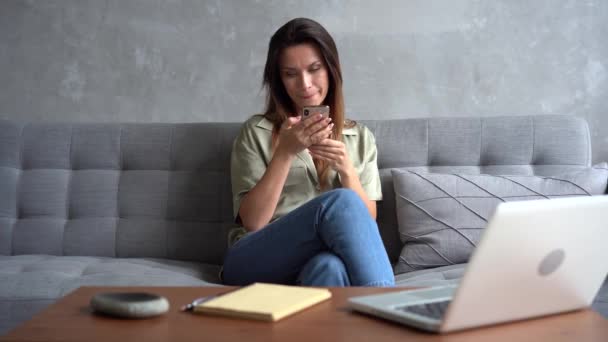 Kvinnen som holder smarttelefon og ser på telefonskjermen med mobilapper for shopping – stockvideo