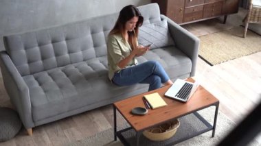 Akıllı telefonu tutan kadın, alışveriş için mobil uygulamalar kullanarak telefon ekranına bakıyor.