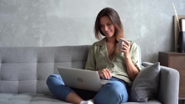 Happy woman relaks na kanapie z laptopem, zakupy w sklepie internetowym — Wideo stockowe