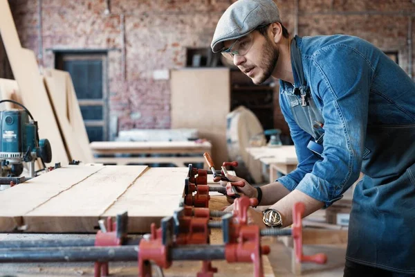 Succesvolle knappe zakenman met stijlvolle pet werk in timmerwerk — Stockfoto