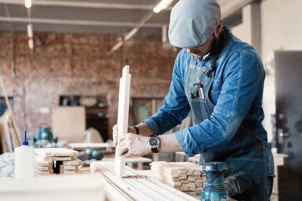 Succesvolle knappe zakenman met stijlvolle pet werk in timmerwerk — Stockfoto