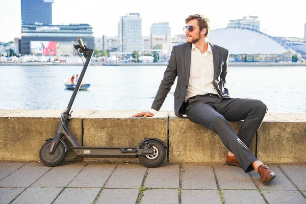 Junger moderner Mann mit Elektroroller auf der Stadtstraße. Modernes und ökologisches Verkehrskonzept. — Stockfoto