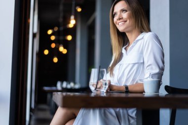 Sabahları restoranda kahve içen bir kadın.
