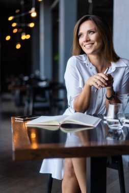 Sabahları restoranda kahve içen bir kadın.