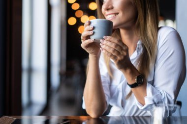 Sabahları restoranda kahve içen bir kadın.