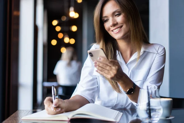 Jeune femme d'affaires utilisant le téléphone dans un café — Photo