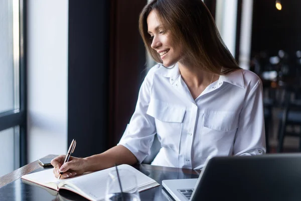 Brunette Femme d'affaires travaillant avec des papiers près de la fenêtre dans un café — Photo