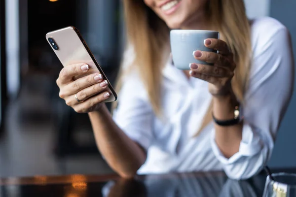 Kahve dükkanında telefon kullanan genç bir iş kadını. — Stok fotoğraf