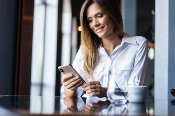 Wanita pengusaha muda menggunakan telepon di warung kopi — Stok Foto