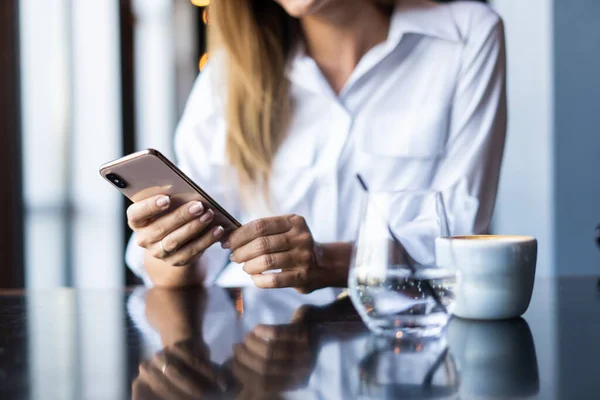 Kahve dükkanında telefon kullanan genç bir iş kadını. — Stok fotoğraf