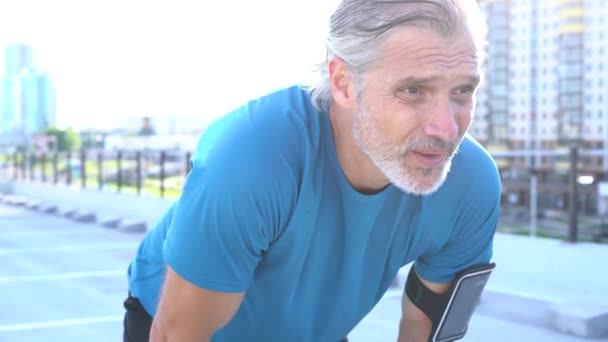 Moderní muž ve sportovním oblečení s přestávkou po joggingu nebo cvičení v městské oblasti — Stock video