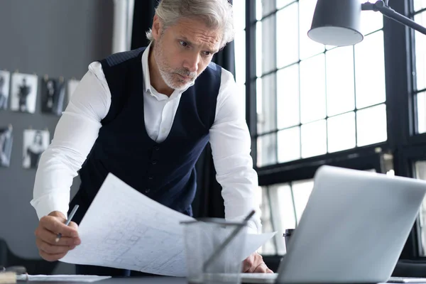 Pensive knappe gerijpte zelfverzekerde zakenman in trendy formele kleding controleren boekhoudkundige rapport — Stockfoto