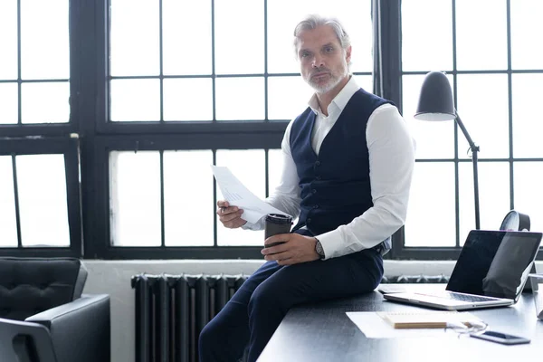 Pensive knappe gerijpte zelfverzekerde zakenman in trendy formele kleding controleren boekhoudkundige rapport — Stockfoto