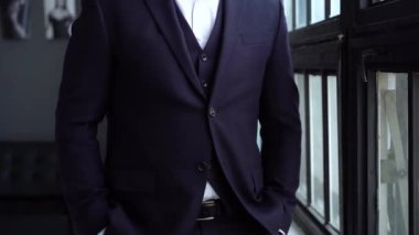 Olgun iş adamı pencerenin yanında dururken gelecekteki projeleri düşünür.