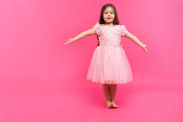 Linda niña sueña con convertirse en una bailarina. Pequeña bailarina. Studio Shoot sobre fondo rosa —  Fotos de Stock