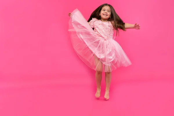 Cute little girl dreams of becoming a ballerina. Little Dancing Girl. Studio Shoot Over Pink Background — Stock Photo, Image
