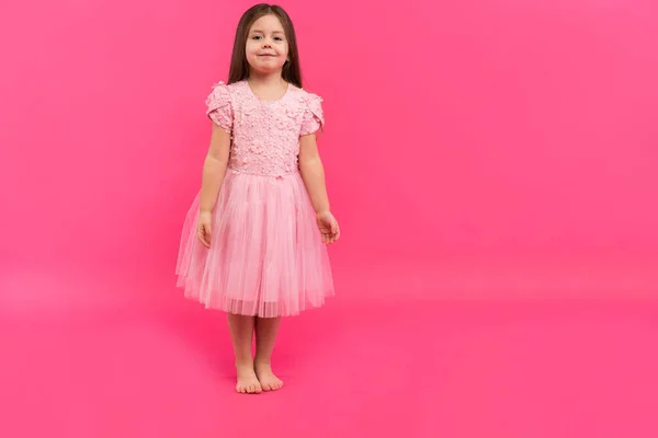 Linda menina sonha em se tornar uma bailarina. Pequena dançarina. Estúdio atirar sobre fundo rosa — Fotografia de Stock