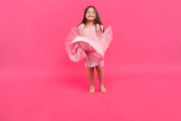 Linda niña sueña con convertirse en una bailarina. Pequeña bailarina. Studio Shoot sobre fondo rosa —  Fotos de Stock