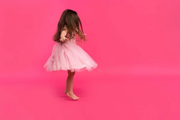 Linda niña sueña con convertirse en una bailarina. Pequeña bailarina. Studio Shoot sobre fondo rosa —  Fotos de Stock