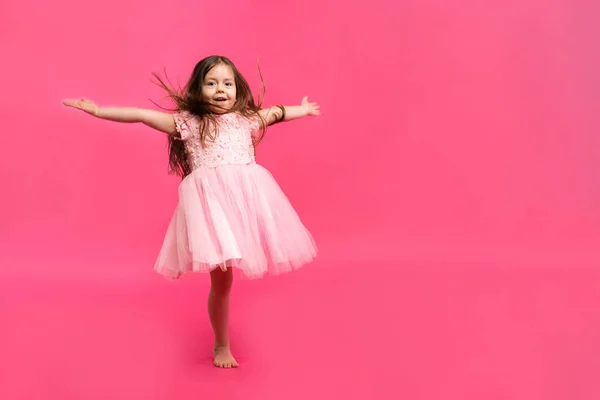 Cute little girl dreams of becoming a ballerina. Little Dancing Girl. Studio Shoot Over Pink Background — Stock Photo, Image