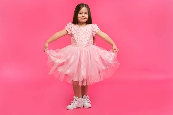 Gadis kecil yang lucu bermimpi menjadi seorang balerina. Gadis penari kecil. Studio Shoot Over Pink Background — Stok Foto